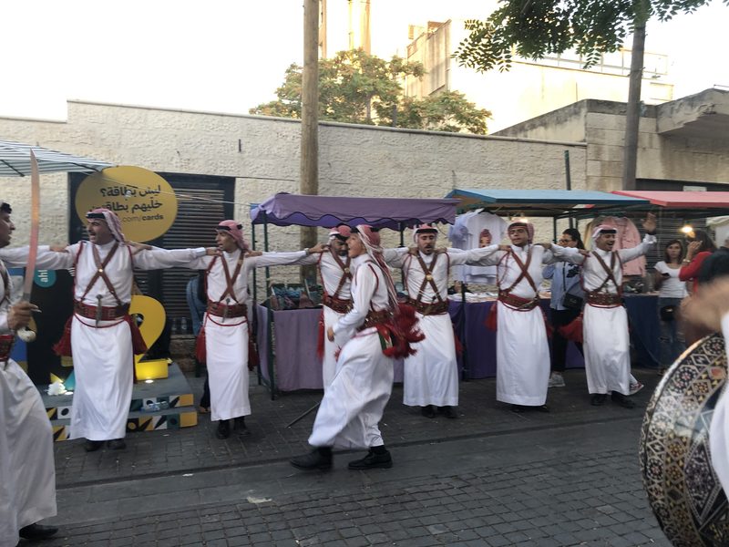 Men in red shemaghs performing dabke
