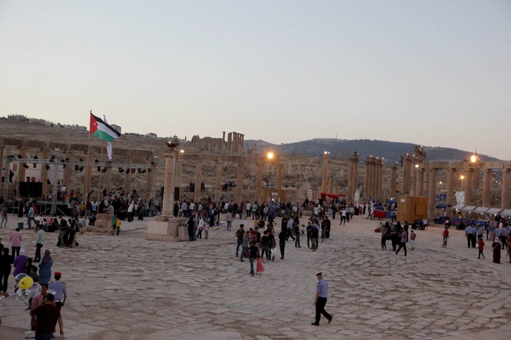 Visitors in a colonnaded plaza at dusk