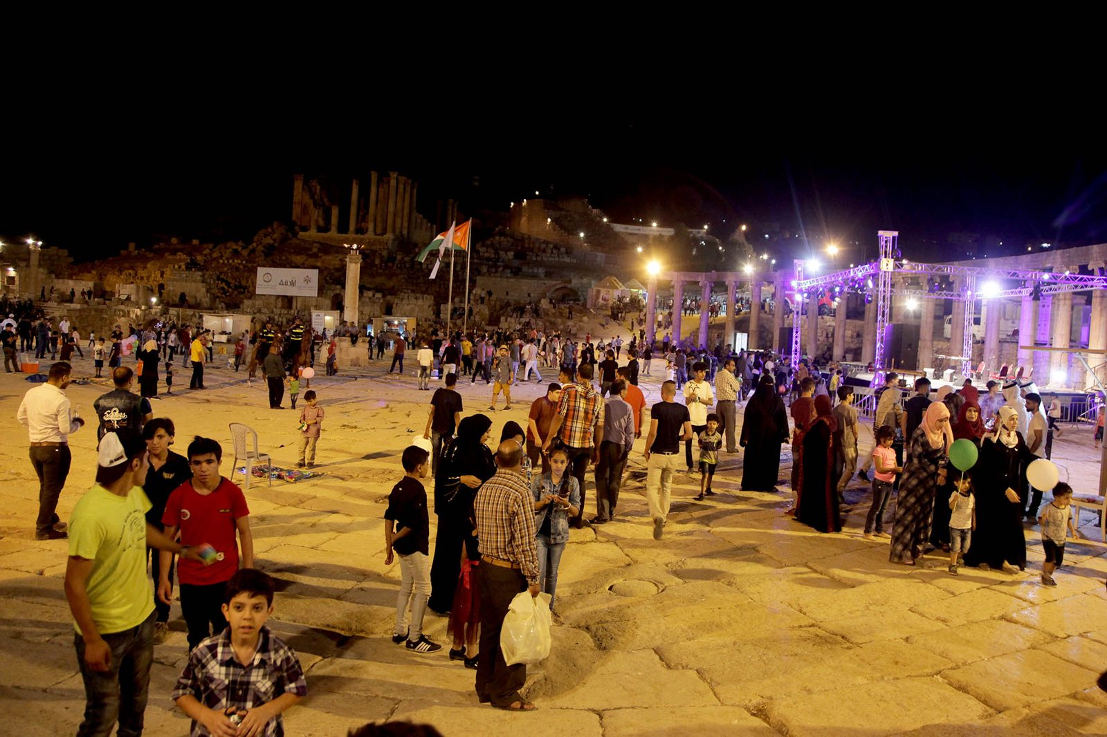 Families gathered in a lit plaza at night