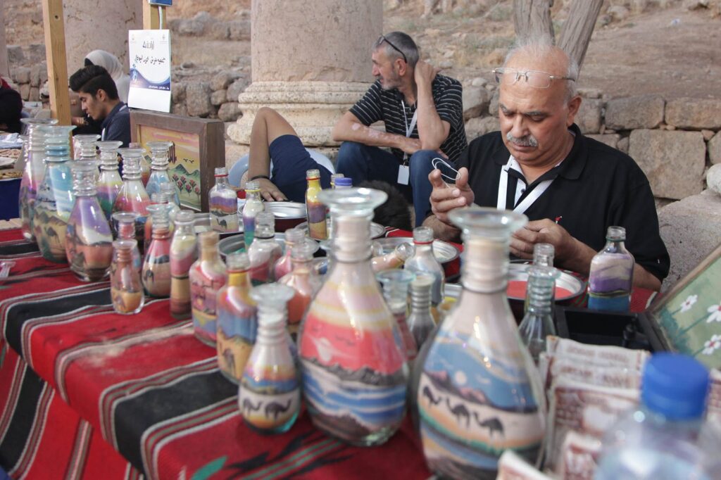 Craftsmen filling bottles with colored sand